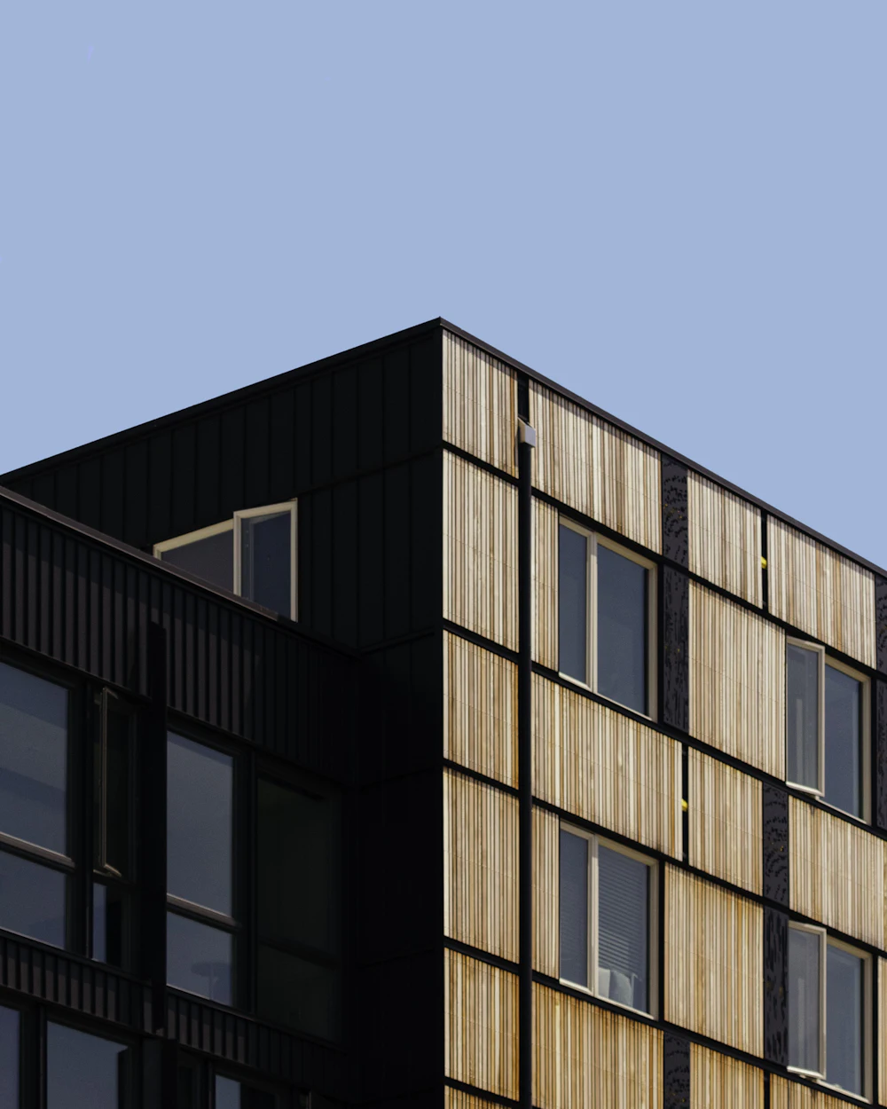 Esquina superior de un edificio residencial de madera y metal contra el cielo